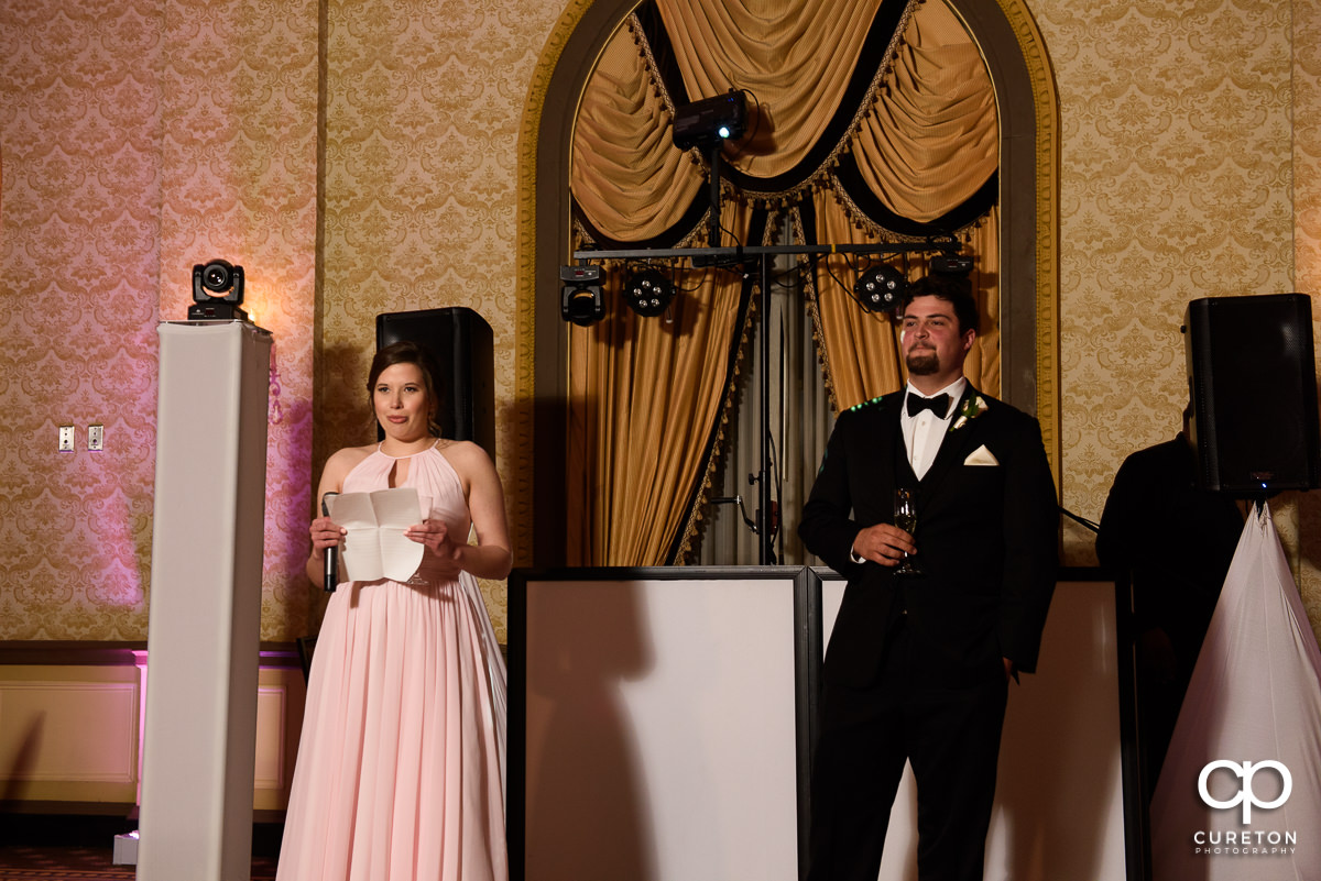 Bridesmaid and groomsmen making a speech at the reception.