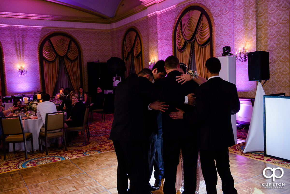 Groomsmen join the groom and mother on the dance floor.