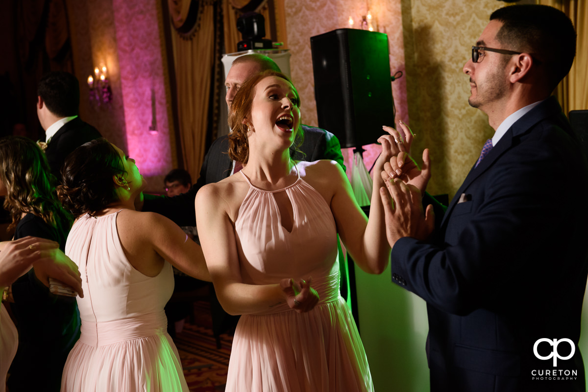 Wedding guests dancing at the wedding reception in the Gold Room of the Westin Poinsett Hotel.