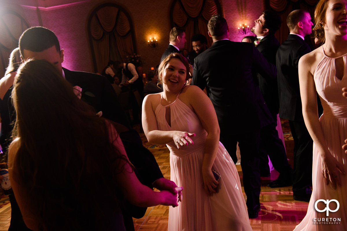 Wedding guests dancing at the wedding reception in the Gold Room of the Westin Poinsett Hotel.