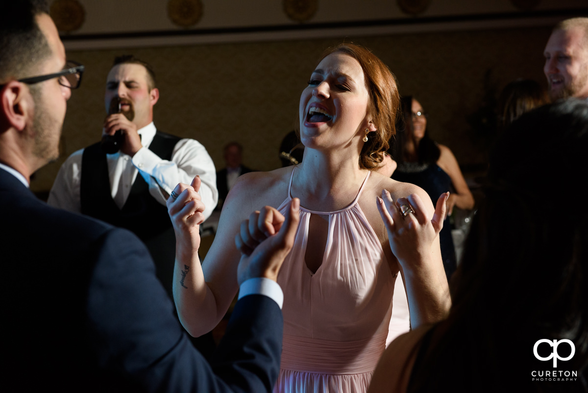 Bridesmaid singing on the dance floor.