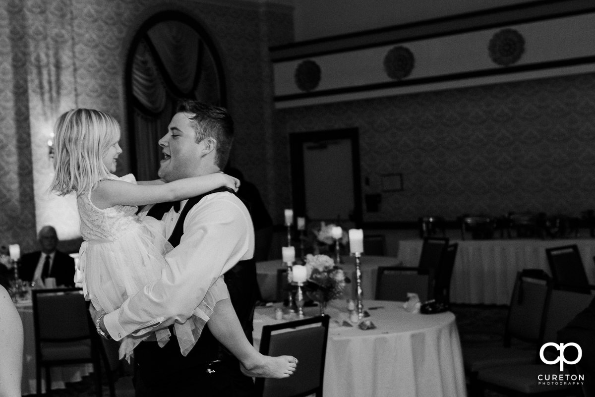 Groom dancing with the flower girl.