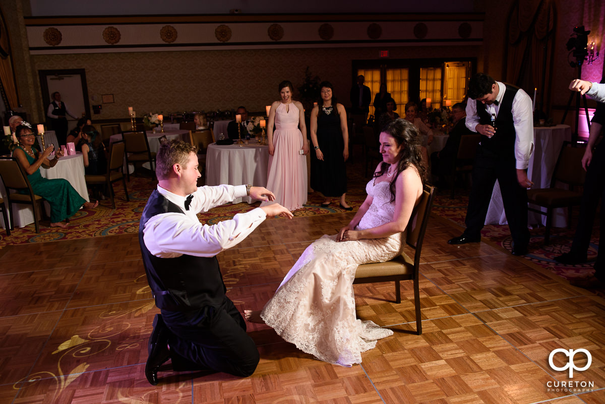 Groom removing the garter.