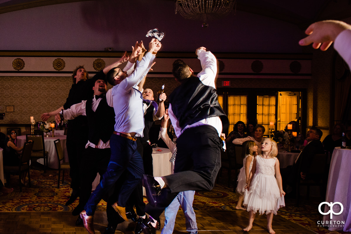 Groomsmen fighting over the garter.