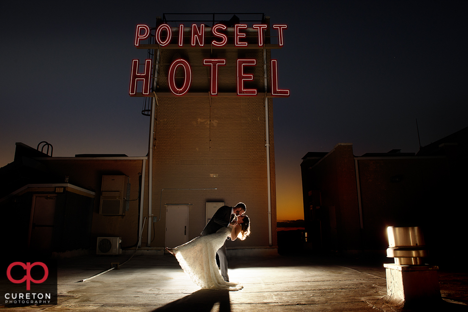 Bride and groom on the roof near the sign at the Westin Poinsett.