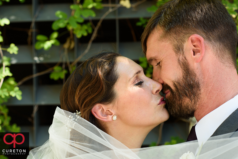 Bride and groom kissing in downtown Greenville before their Westin Poinsett wedding.