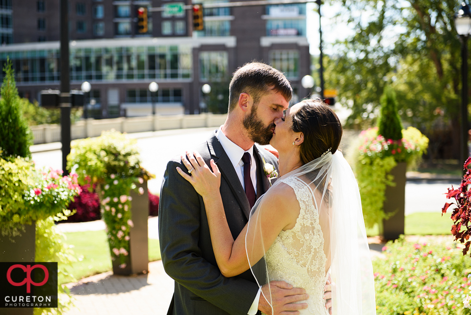 Bride and groom kissing on the streets of downtown Greenville.