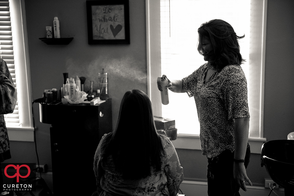 Bridesmaid getting hairspray applied.