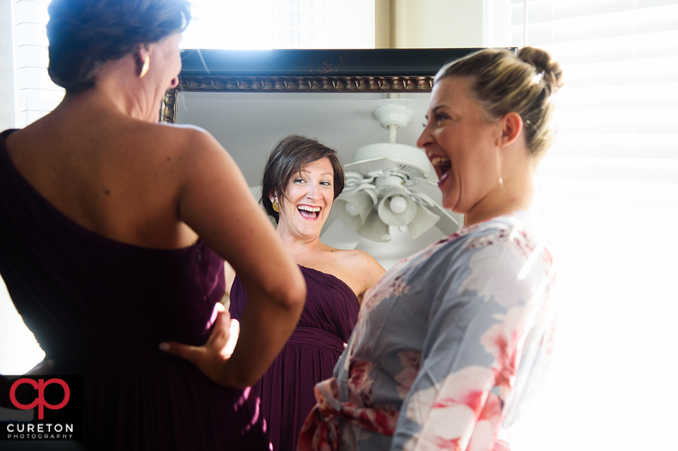 Bridesmaids laughing while getting ready.
