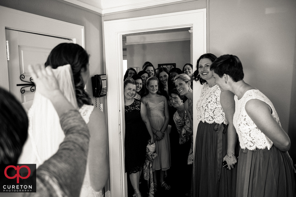 Bridesmaids watching as the bride is revealed.