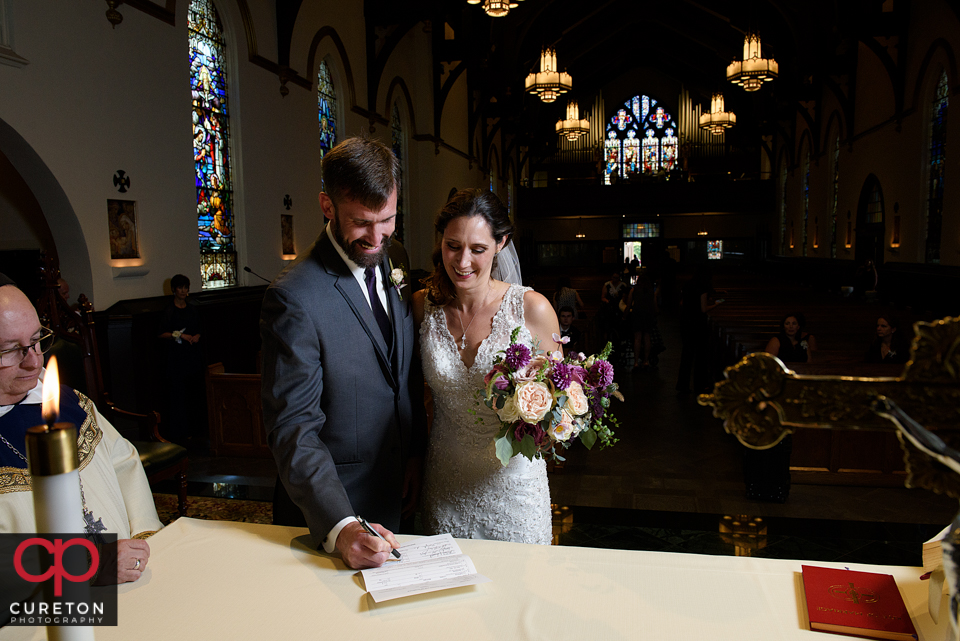 Bride and groom signing the marriage license at St. Mary's.