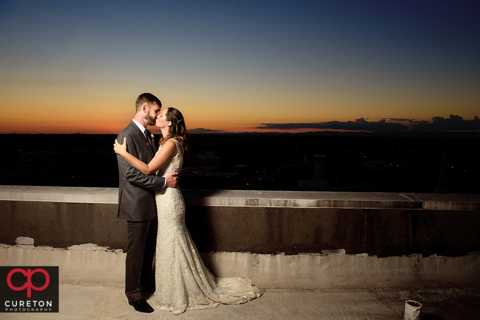 Bride and groom sharing a sunset on the roof.