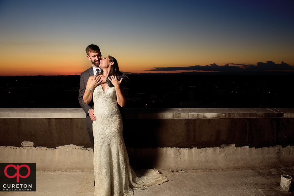 Bride and groom on the roof at sunset.