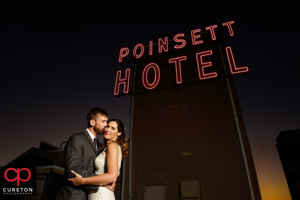 Bride and groom with the Westin Poinsett hotel sign.