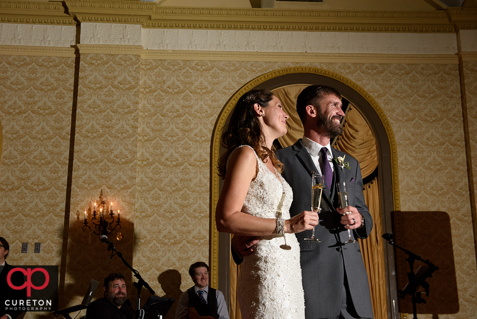 Bride and groom watching as the best man raises a toast.