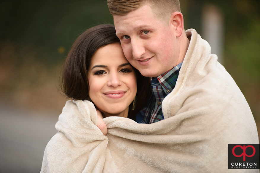 Couple snuggling during an engagement session.