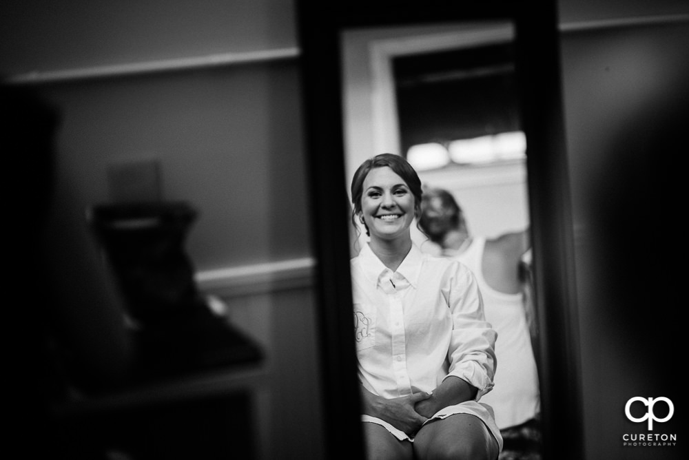 Bride looking at her makeup in the mirror.