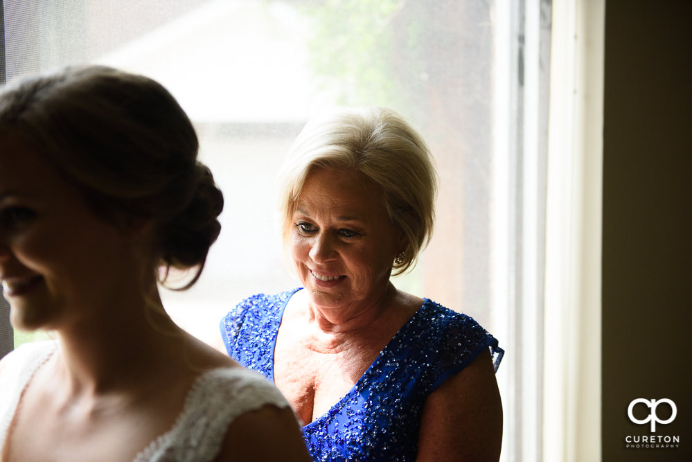 Bride's mom helping her get ready.