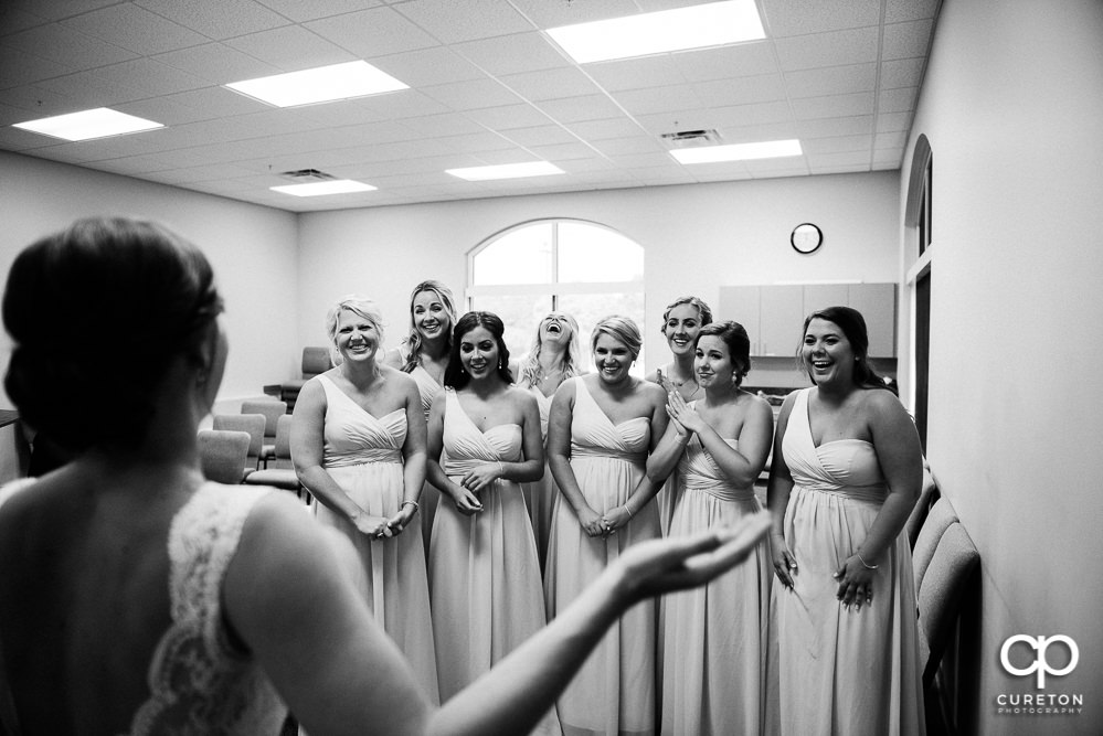 Bride revealing the dress to the bridesmaids.