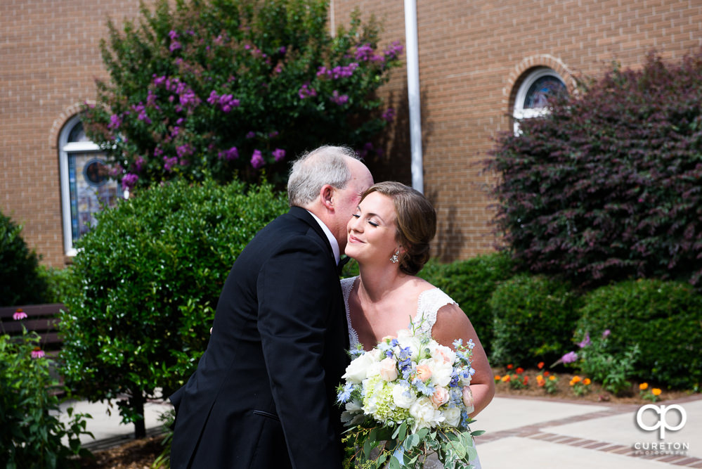Bride having a first look with her dad in the courtyard of Covenant United Methodist Church.