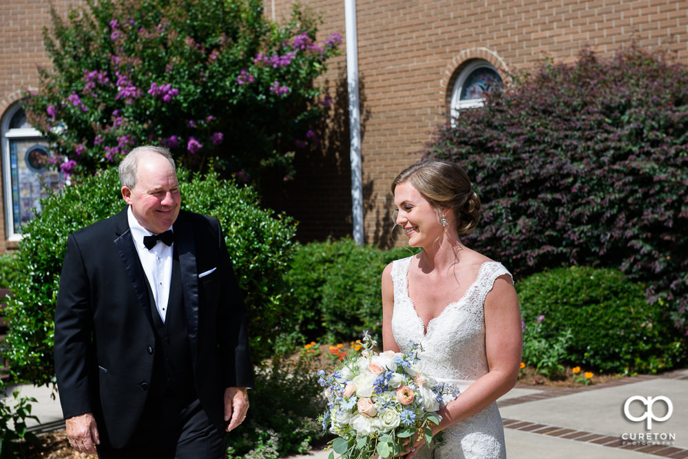 Bride having a first look with her dad in the courtyard of Covenant United Methodist Church.