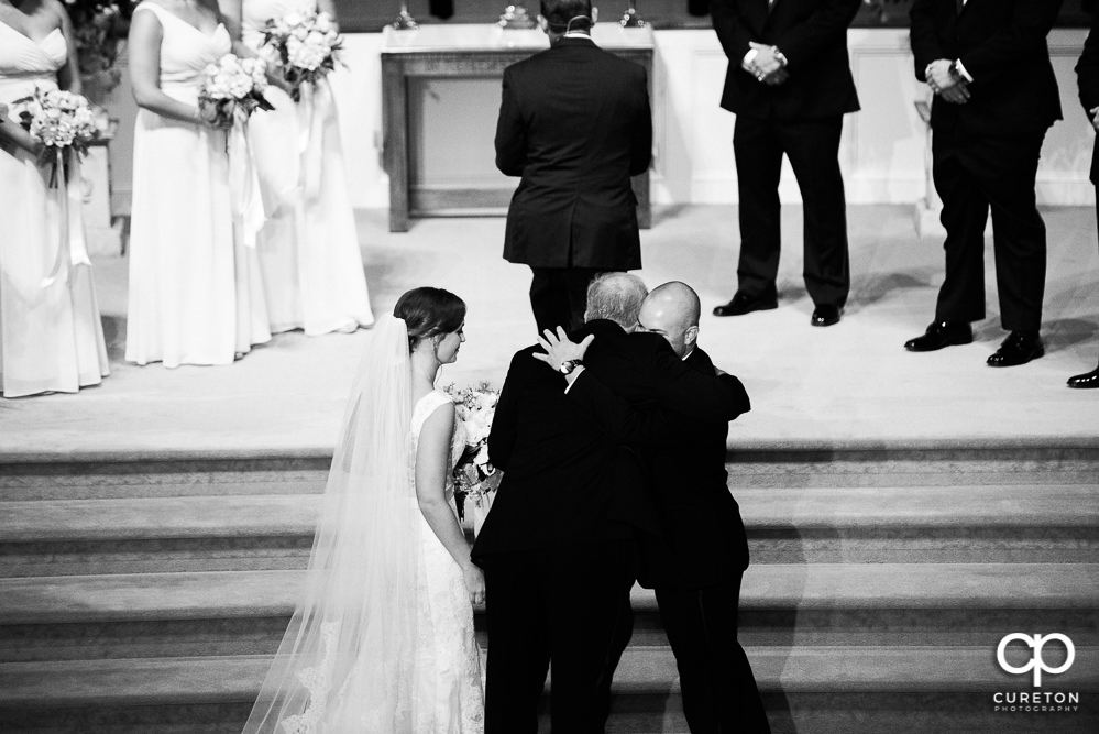 Bride's father hugging the groom.