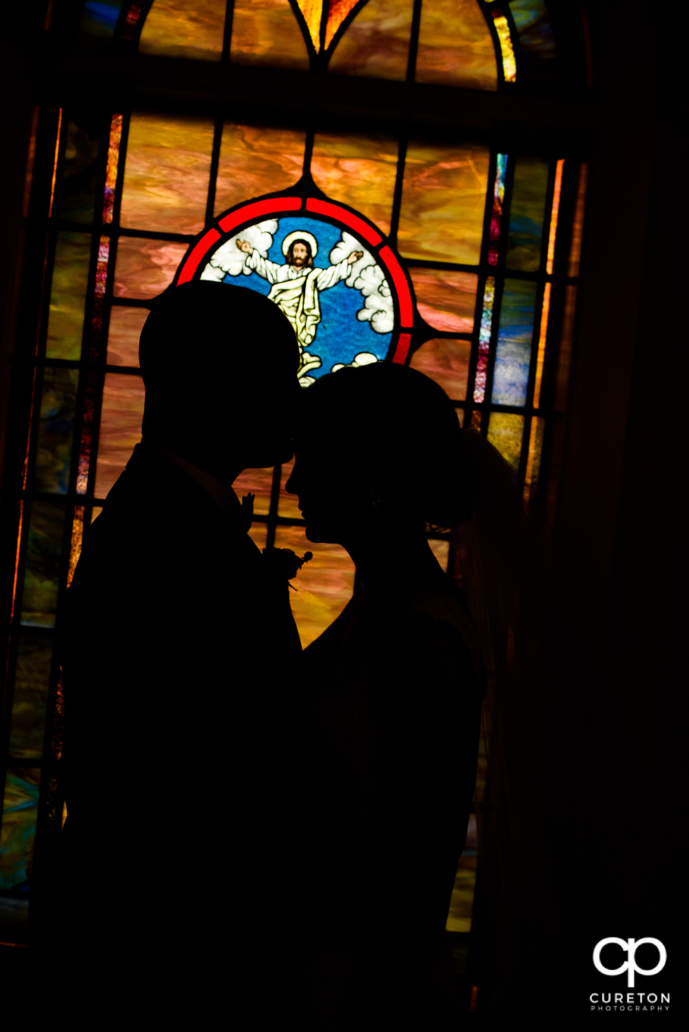 Silhouette of bride and groom in stained glass.